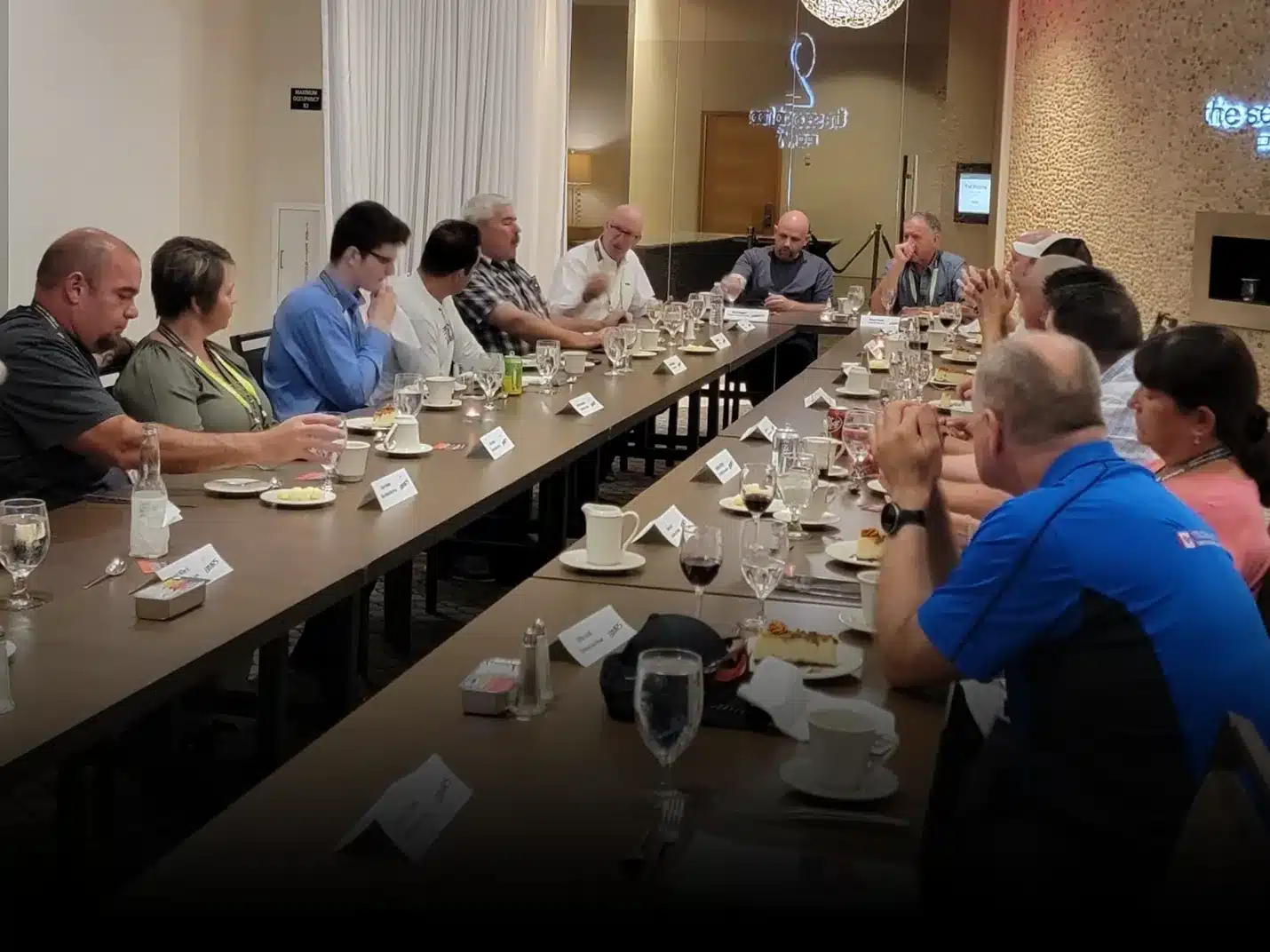 Teaching at BIMRS Conference., Group of people sitting at a long table with food and beverages.