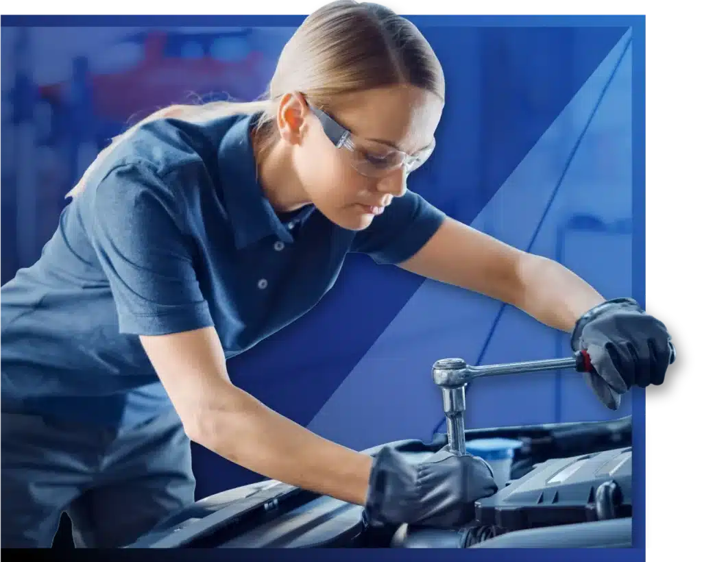 A woman focused on repairing a car engine, tools scattered around her, showcasing her skills and determination.